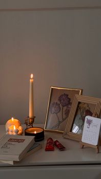 Warm still life featuring candles, books, and framed art creating a cozy ambiance.
