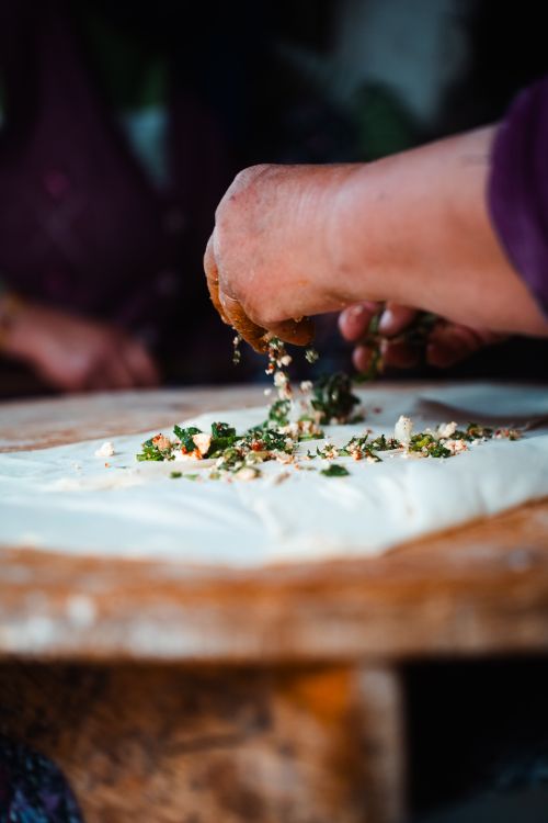 Free Close-up of hands preparing Turkish pastry with greens in Antalya. Stock Photo