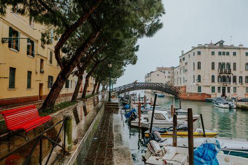 Free Scenic view of a canal with boats and architecture in rainy Venice, Italy. Stock Photo