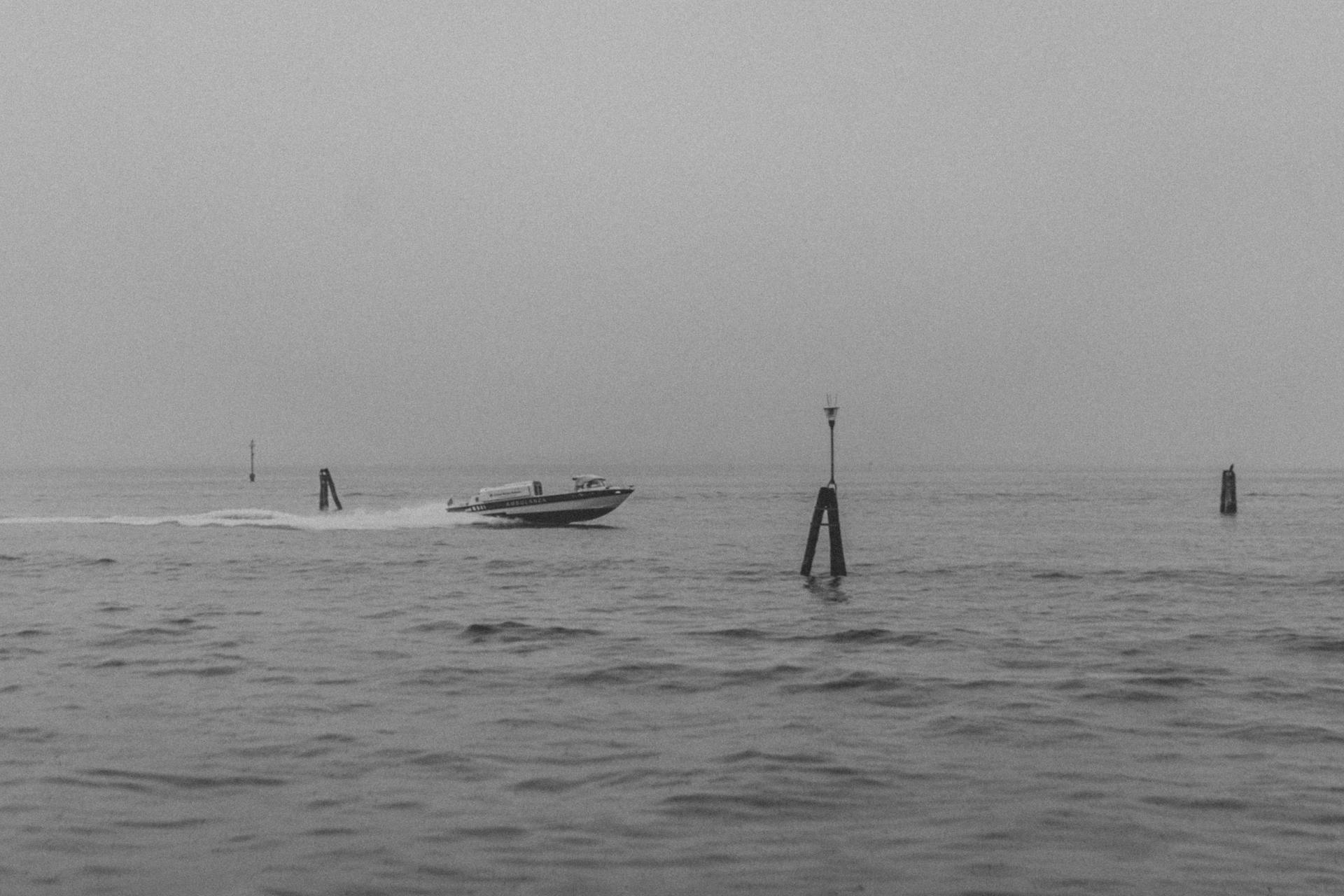 Black and white photo of a speedboat on a calm sea creates a serene, vintage mood.