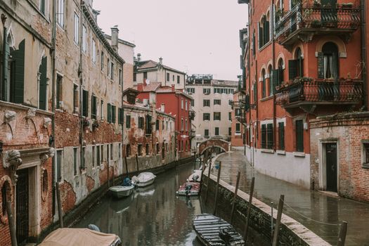 A tranquil view of a Venetian canal lined with historic buildings, offering a glimpse into Italy's architectural beauty.