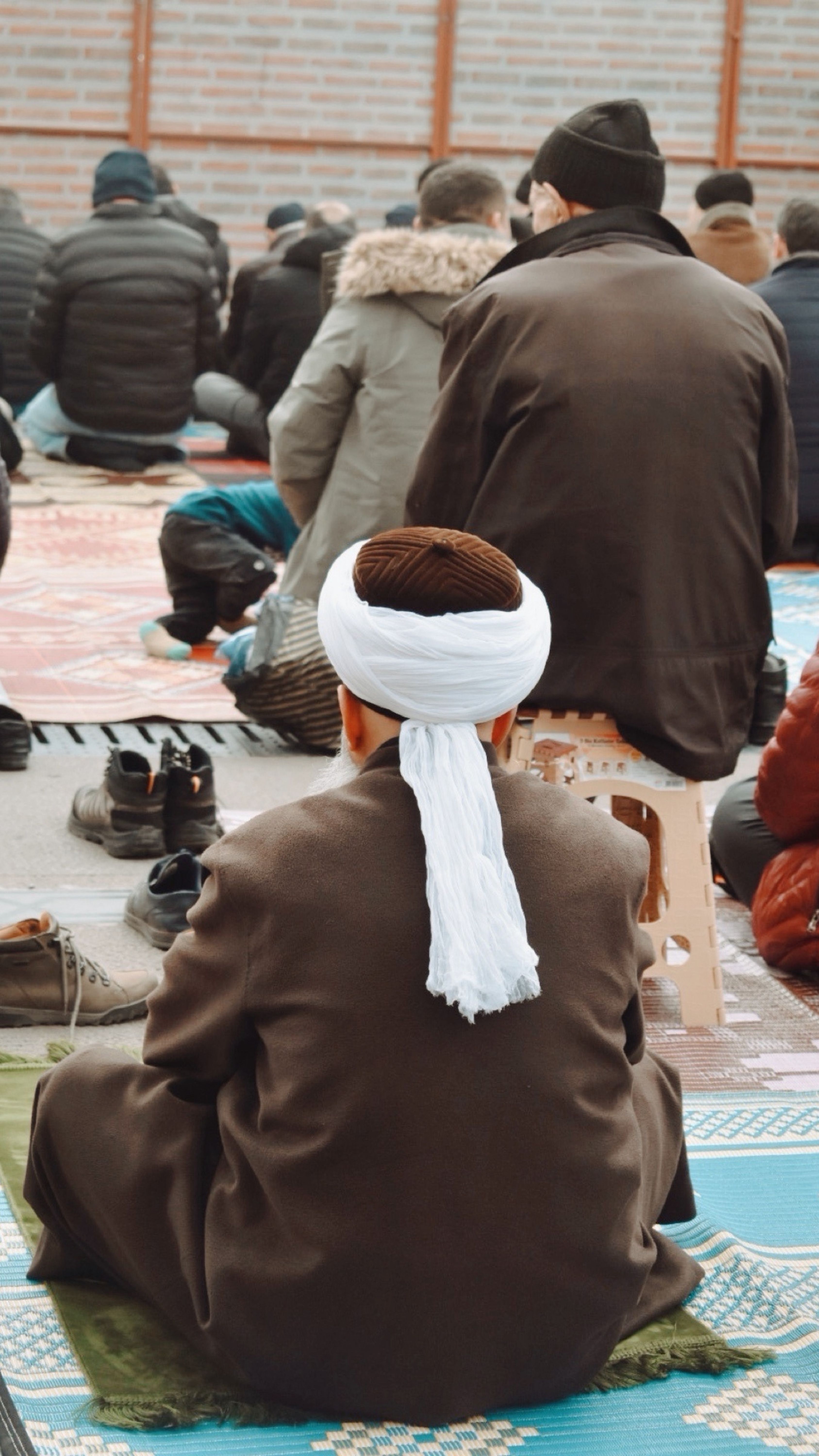A group of people participating in an outdoor religious gathering with focus on cultural attire.