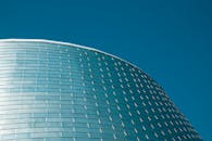 在加拿大蒙特利尔，现代建筑的弧形玻璃立面优雅地映衬着清澈的蓝天