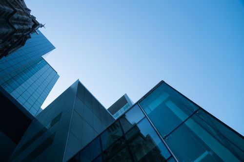 Free Low angle view of modern skyscrapers with glass facades against a clear blue sky. Stock Photo