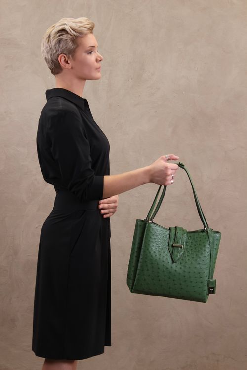 Free Profile of a stylish woman holding a green handbag, showcasing modern fashion elegance. Stock Photo
