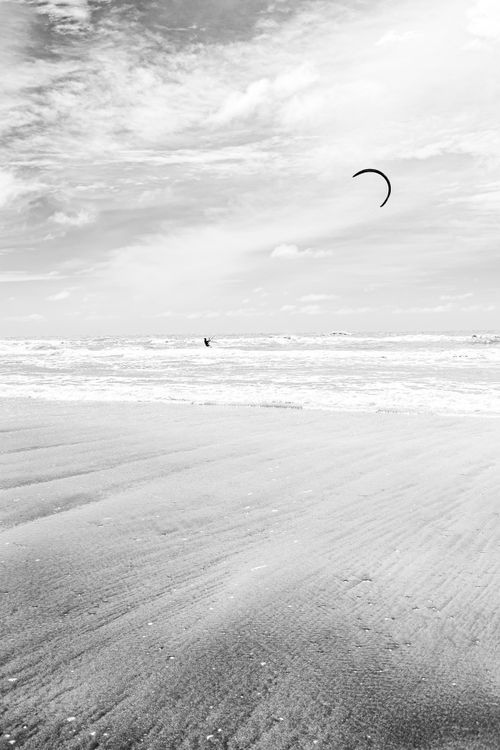 Free A peaceful monochrome scene of a kitesurfer enjoying the waves at La Lucila del Mar. Stock Photo