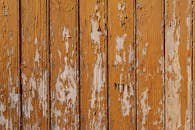 特写镜头下，老化木板的棕色油漆剥落，展现出乡村纹理和饱经风霜的外观