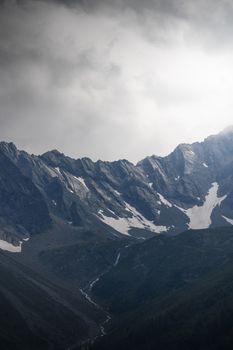 Explore the captivating alpine landscape of Längenfeld, Tirol, with dramatic mountains and cloudy skies.