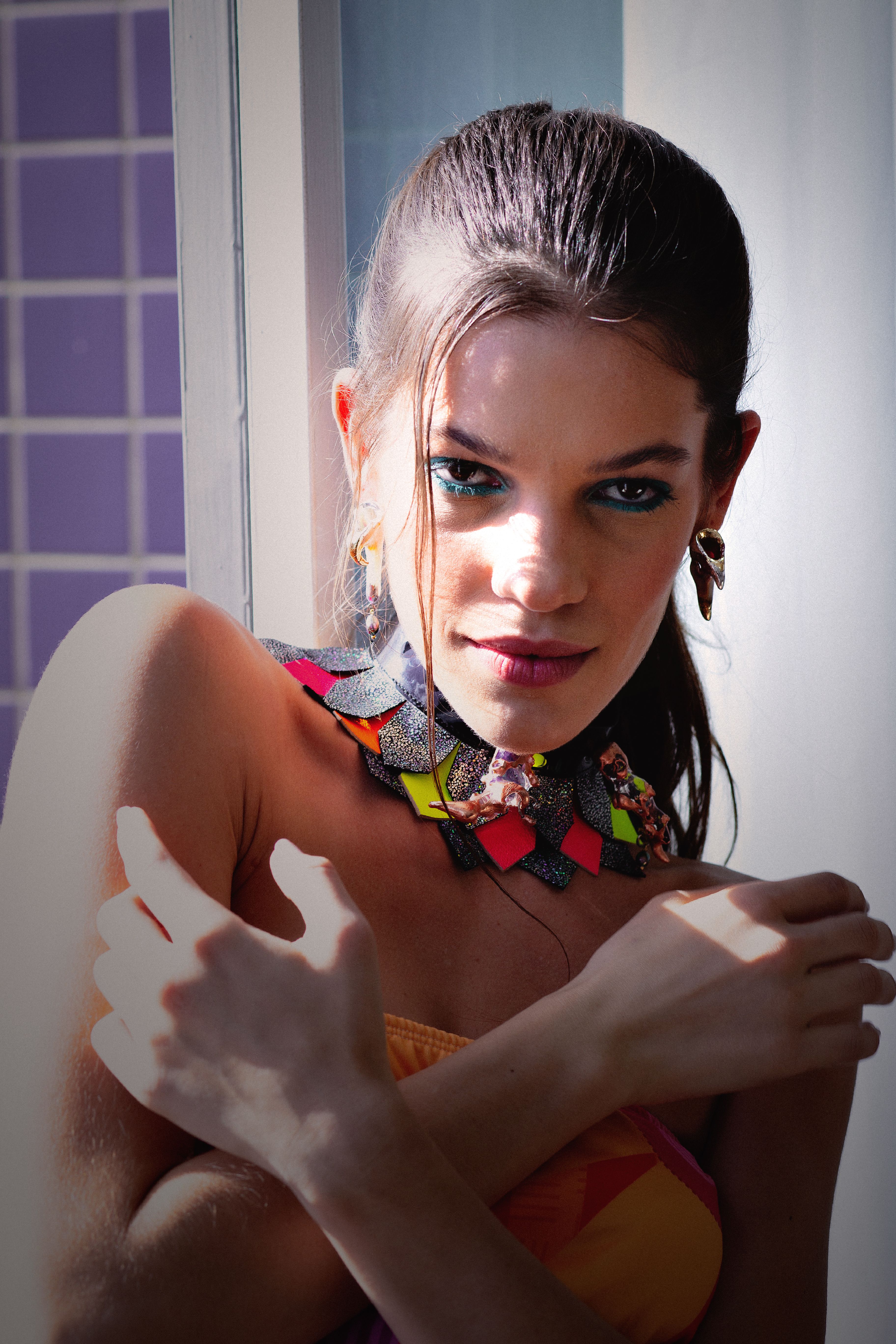 Striking portrait of a woman wearing colorful jewelry in natural light, capturing elegance and style.