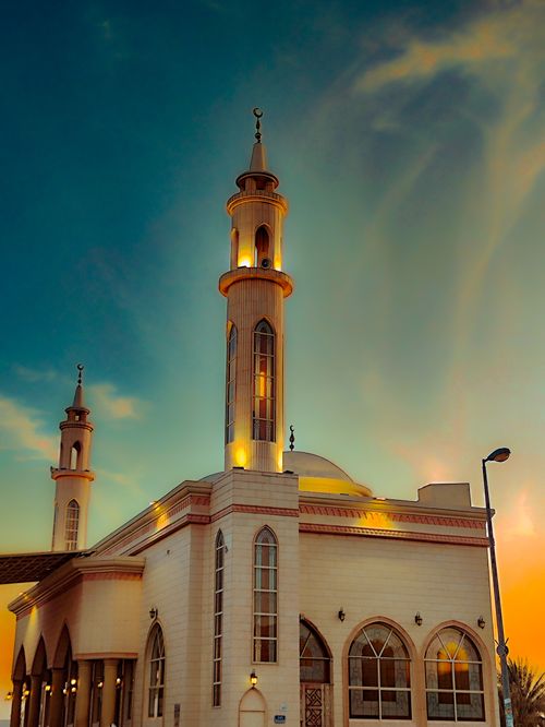 Free Stunning mosque architecture under a vibrant sky at sunrise, featuring elegant minarets. Stock Photo