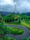 Scenic Curved Road in Lush Greenery and Hills