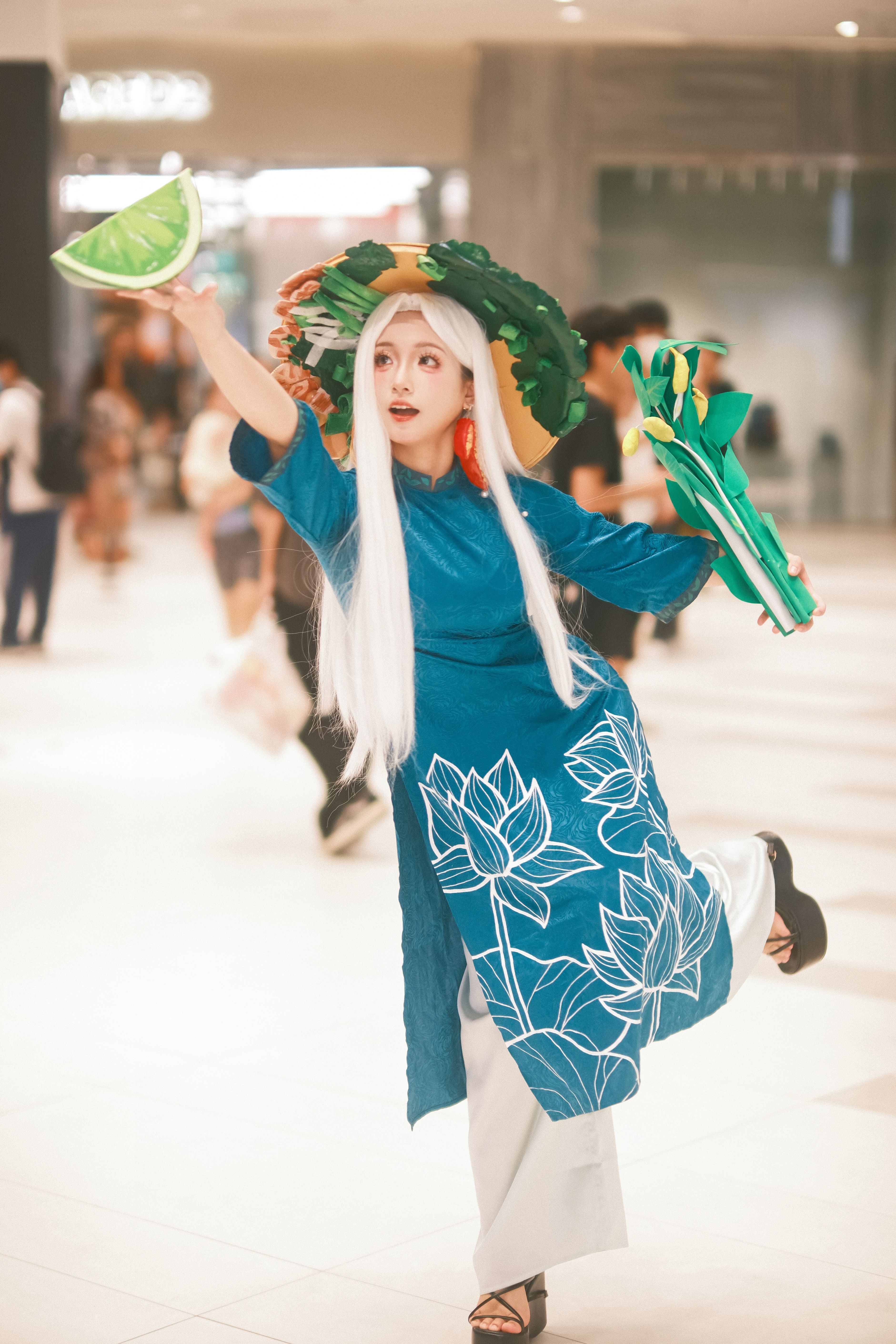 A vibrant cosplay performer in traditional attire with lotus patterns, set in a bustling shopping mall.