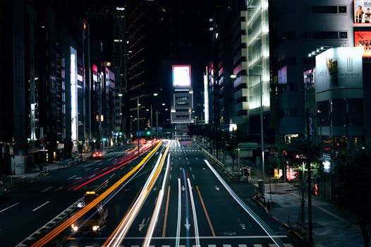 Night view of Tokyo's vibrant streets with dynamic light trails enhancing the cityscape.