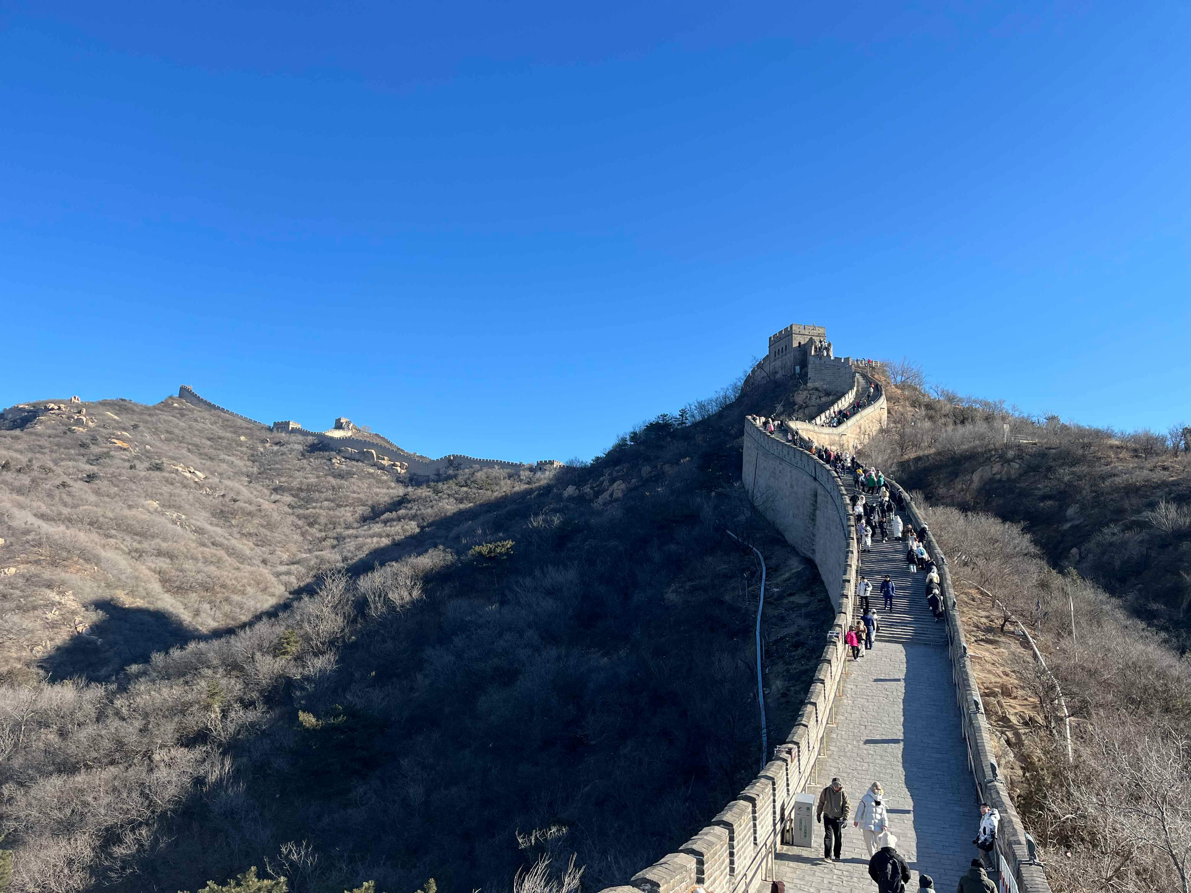 great wall of china with tourists in winter sunlight