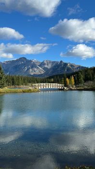 Beautiful mountain landscape with a wooden bridge and lake in autumn.