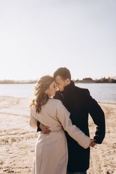 A couple sharing a tender moment on a sunny beach, showcasing romance and connection.