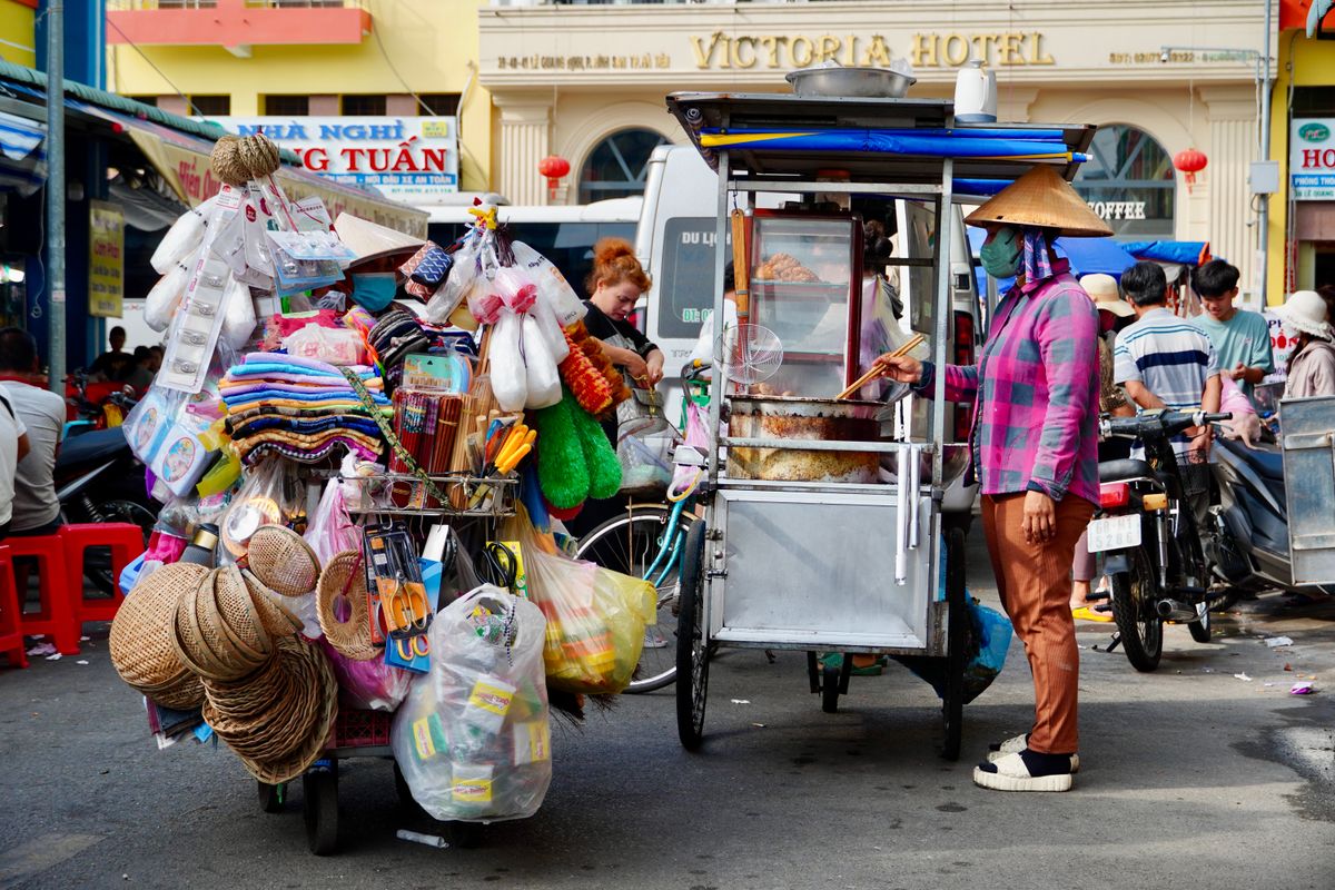 Vibrant street market scene in Southeast Asia with vendors and traditional food