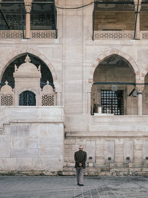 Free Elderly man gazing at traditional architecture in Istanbul, Turkey, showcasing intricate stonework. Stock Photo