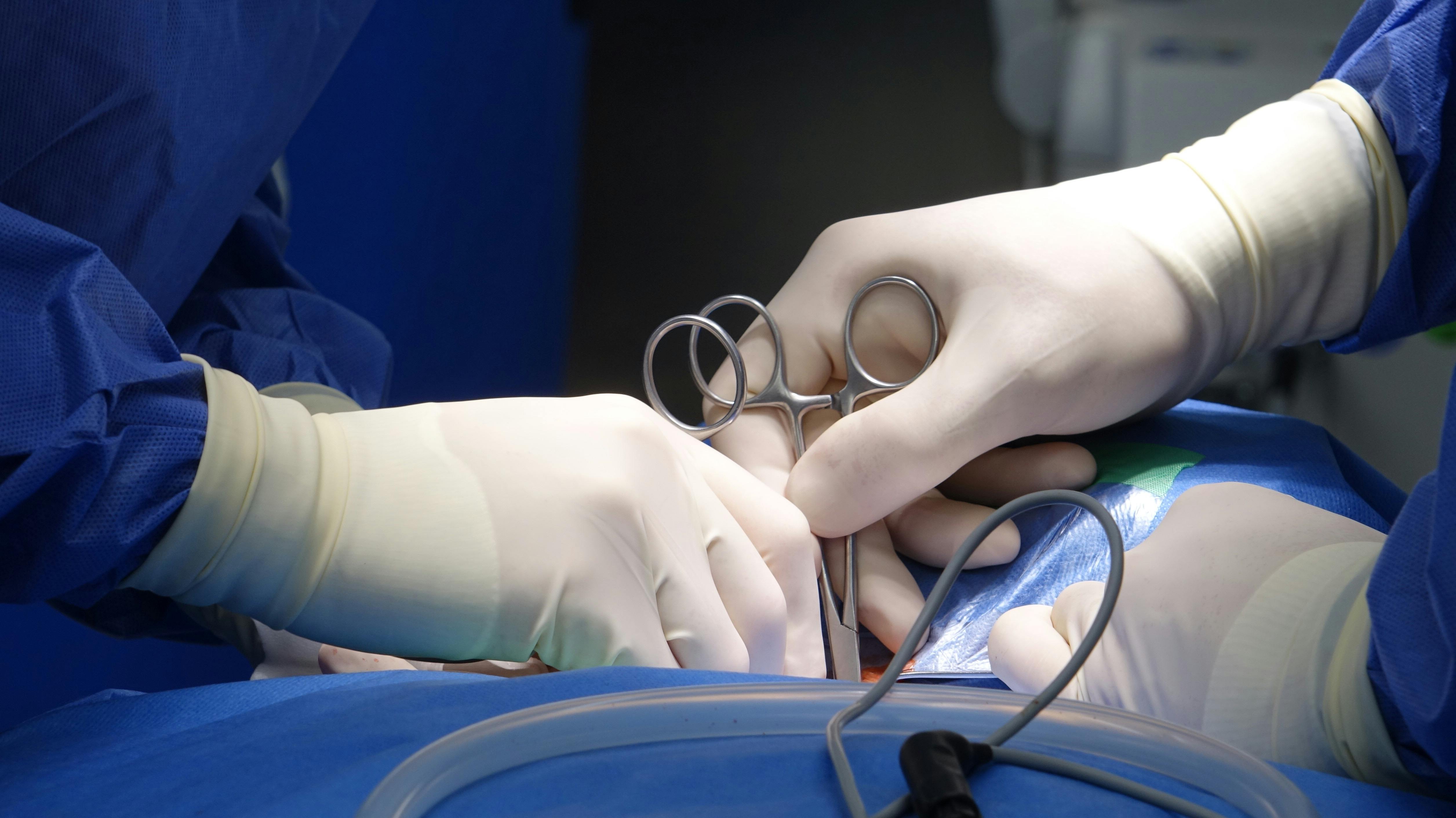 Close-up of surgeons' hands in surgical gloves performing an operation in a hospital operating room under sterile conditions.