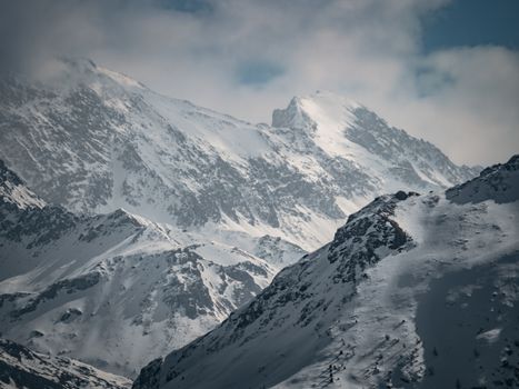 Breathtaking view of snow-covered mountains in Surses, Graubünden, Switzerland during winter.