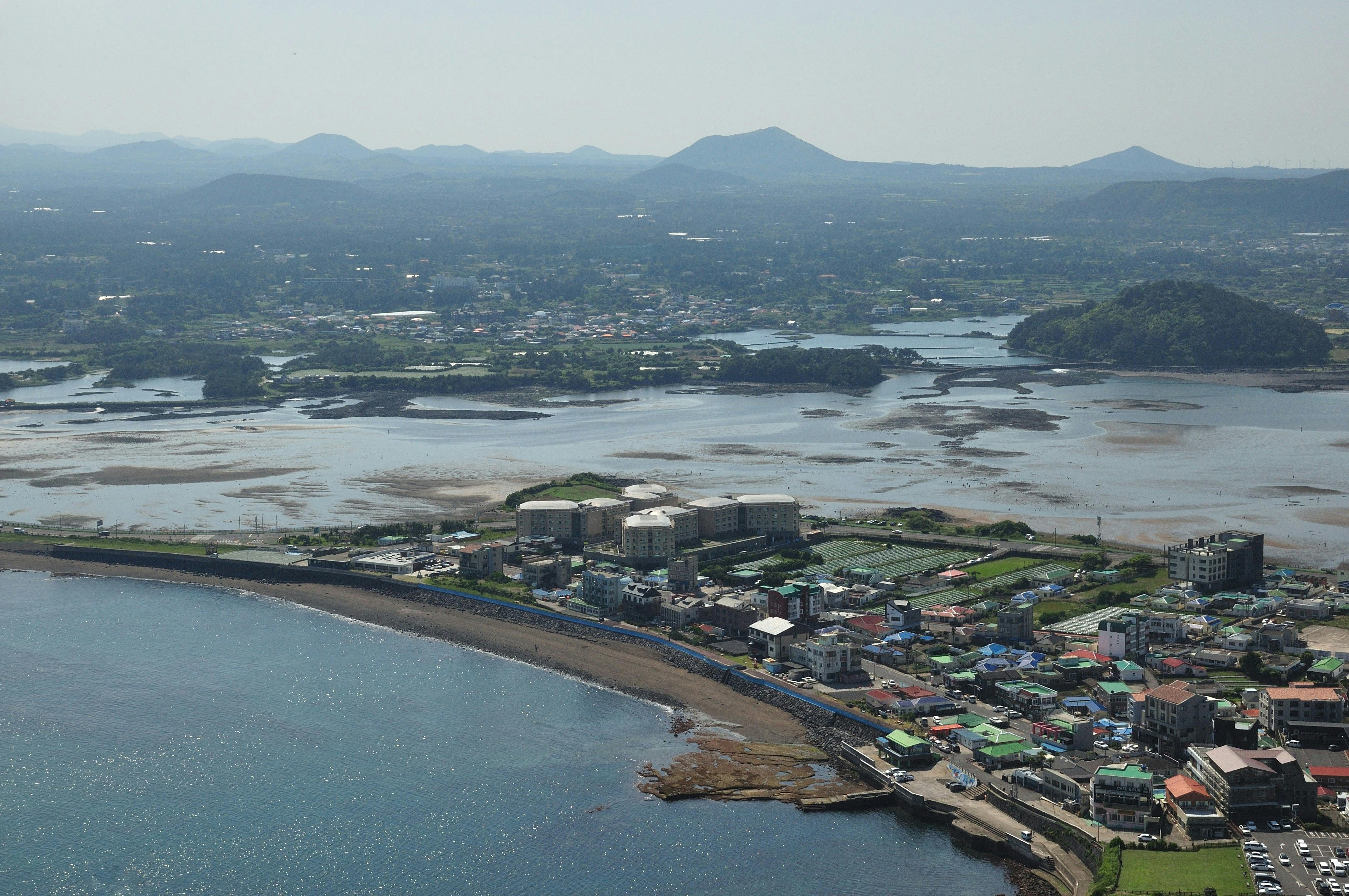 A stunning aerial photo capturing a coastal town in South Korea, with a mix of nature and architecture.
