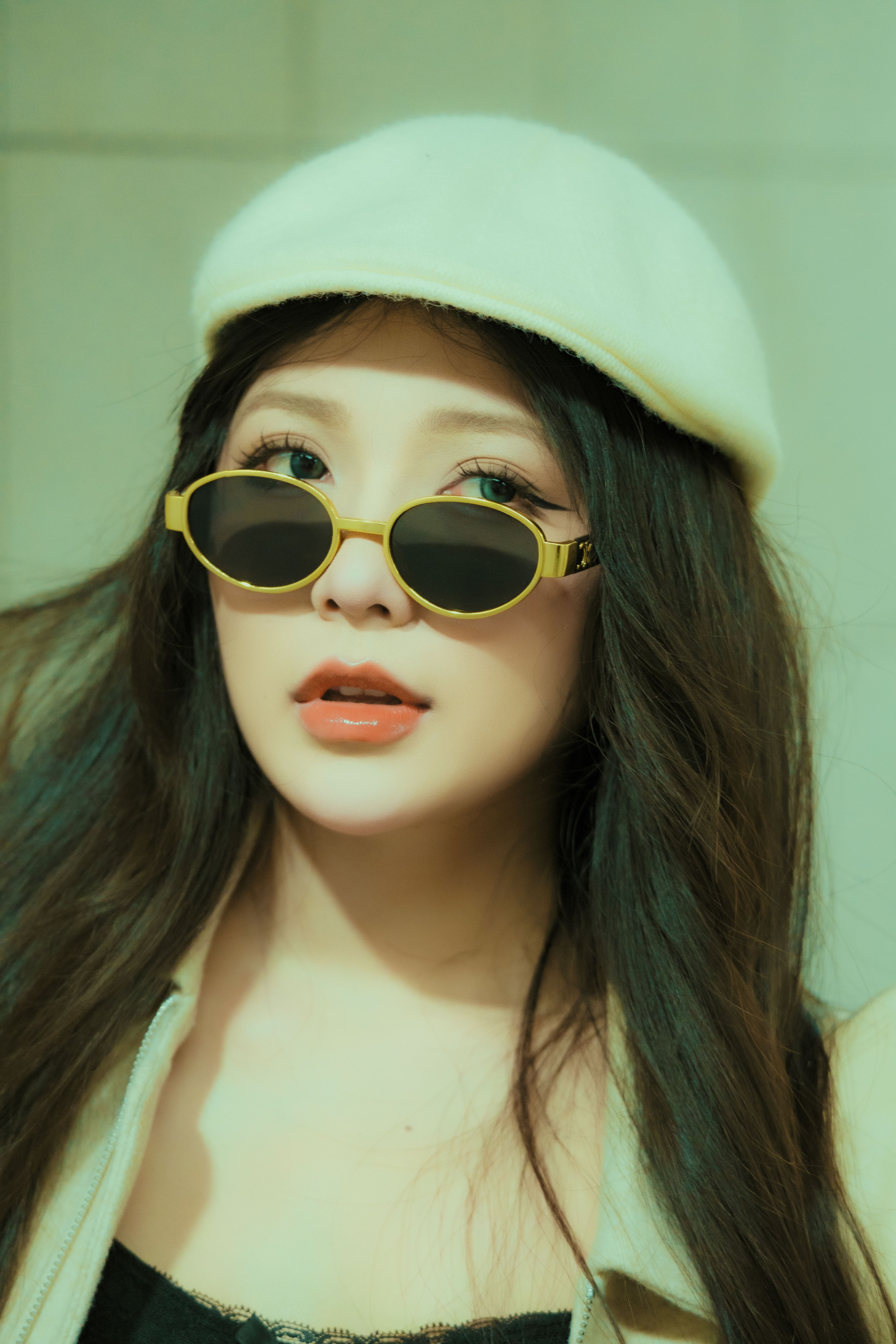 Fashionable woman in sunglasses and beret posing indoors with stylish sunglasses.