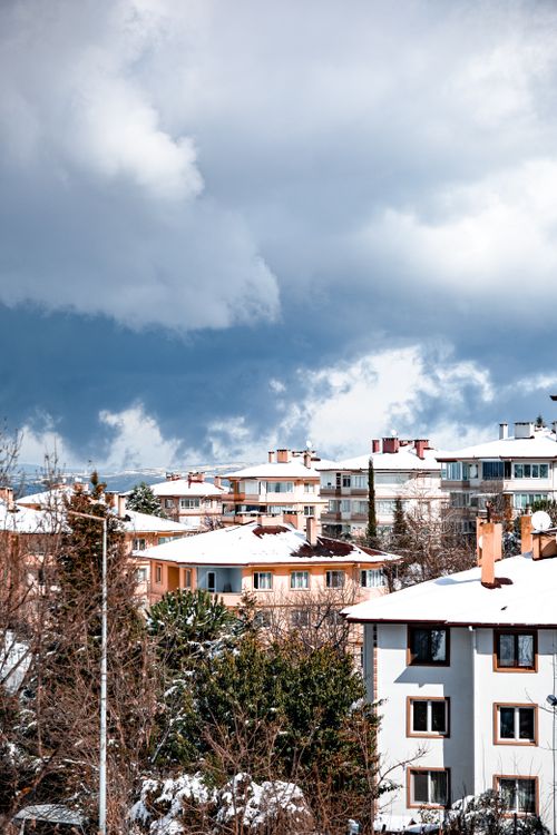 Free Snow-covered roofs in Yalova, Türkiye against a dramatic winter sky. Stock Photo