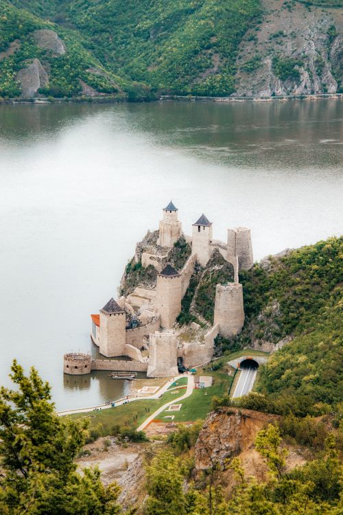 Free Stunning aerial view of Golubac Fortress along the Danube River surrounded by lush green hills in Serbia. Stock Photo