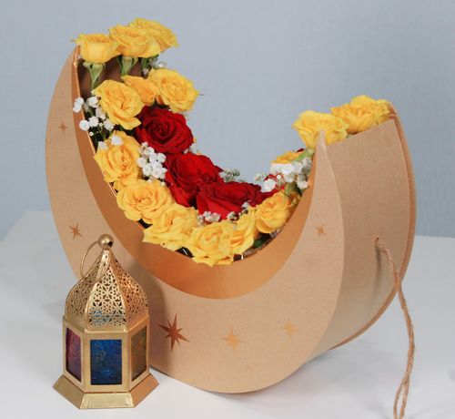 Free Beautiful floral arrangement in crescent shape with roses and an ornate lantern, perfect for celebrations. Stock Photo