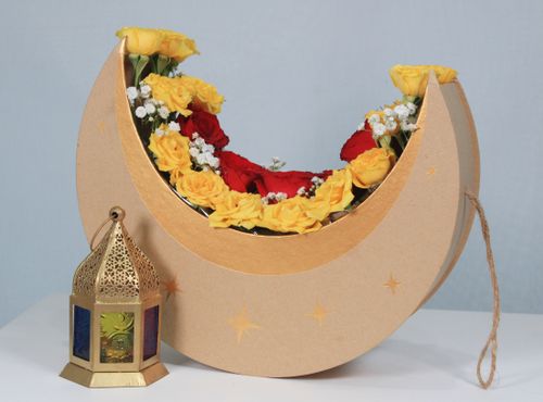 Free A crescent-shaped floral arrangement with yellow and red roses next to an ornate lantern. Stock Photo