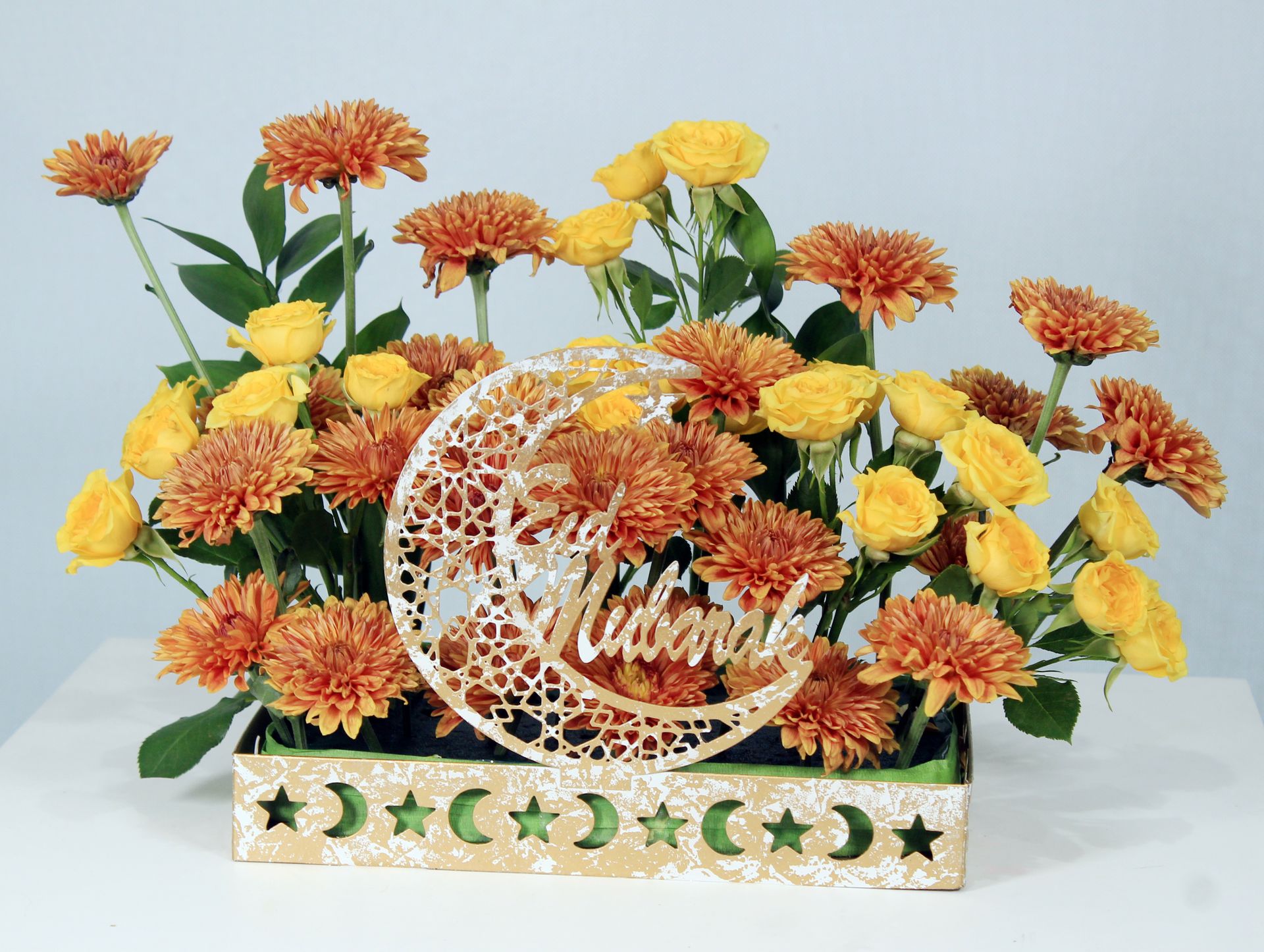 Elegant Eid Mubarak floral arrangement featuring yellow roses and orange chrysanthemums.