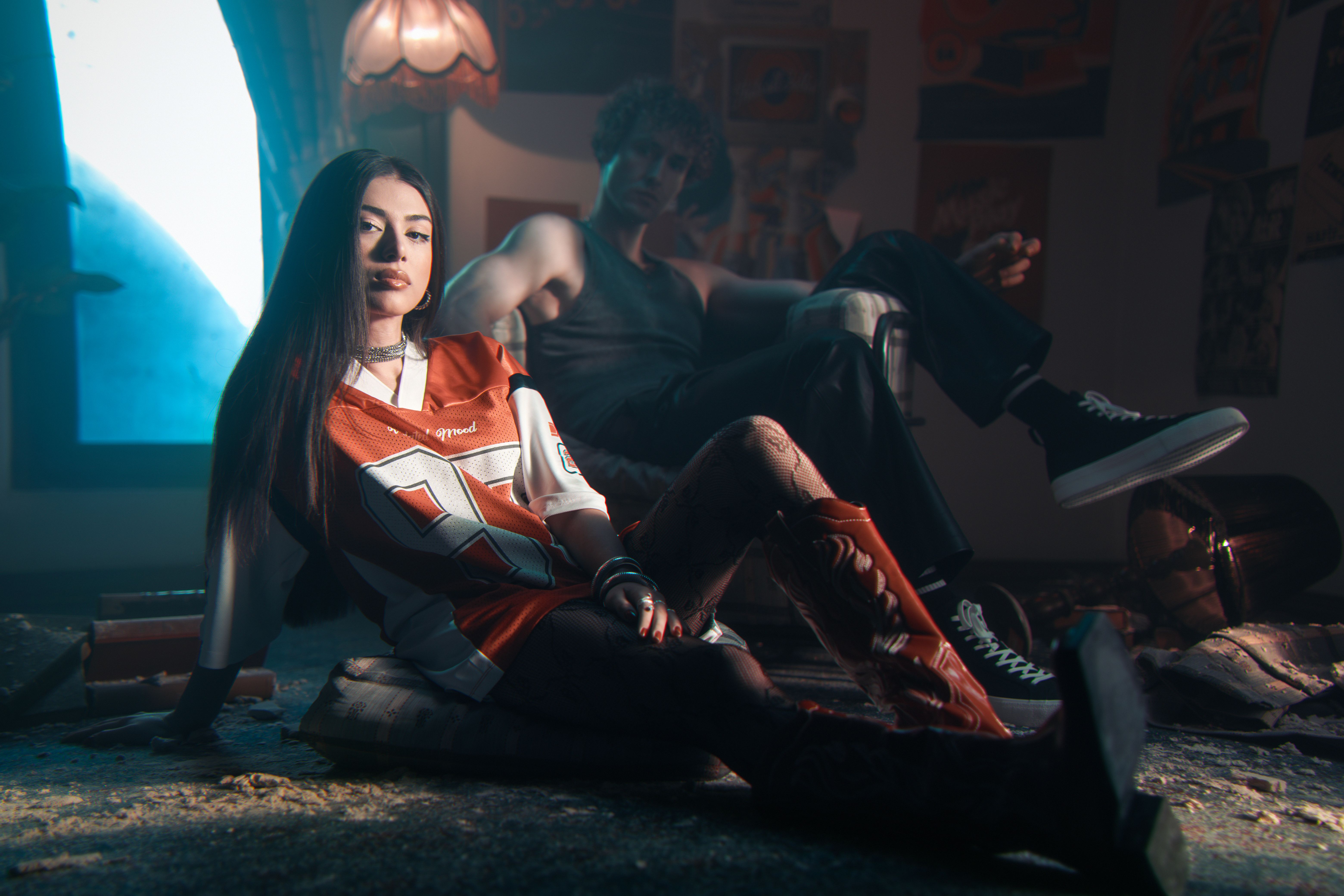 Jeune femme en maillot de football stylisé, tenue blokecore urbaine aux lumières tamisées