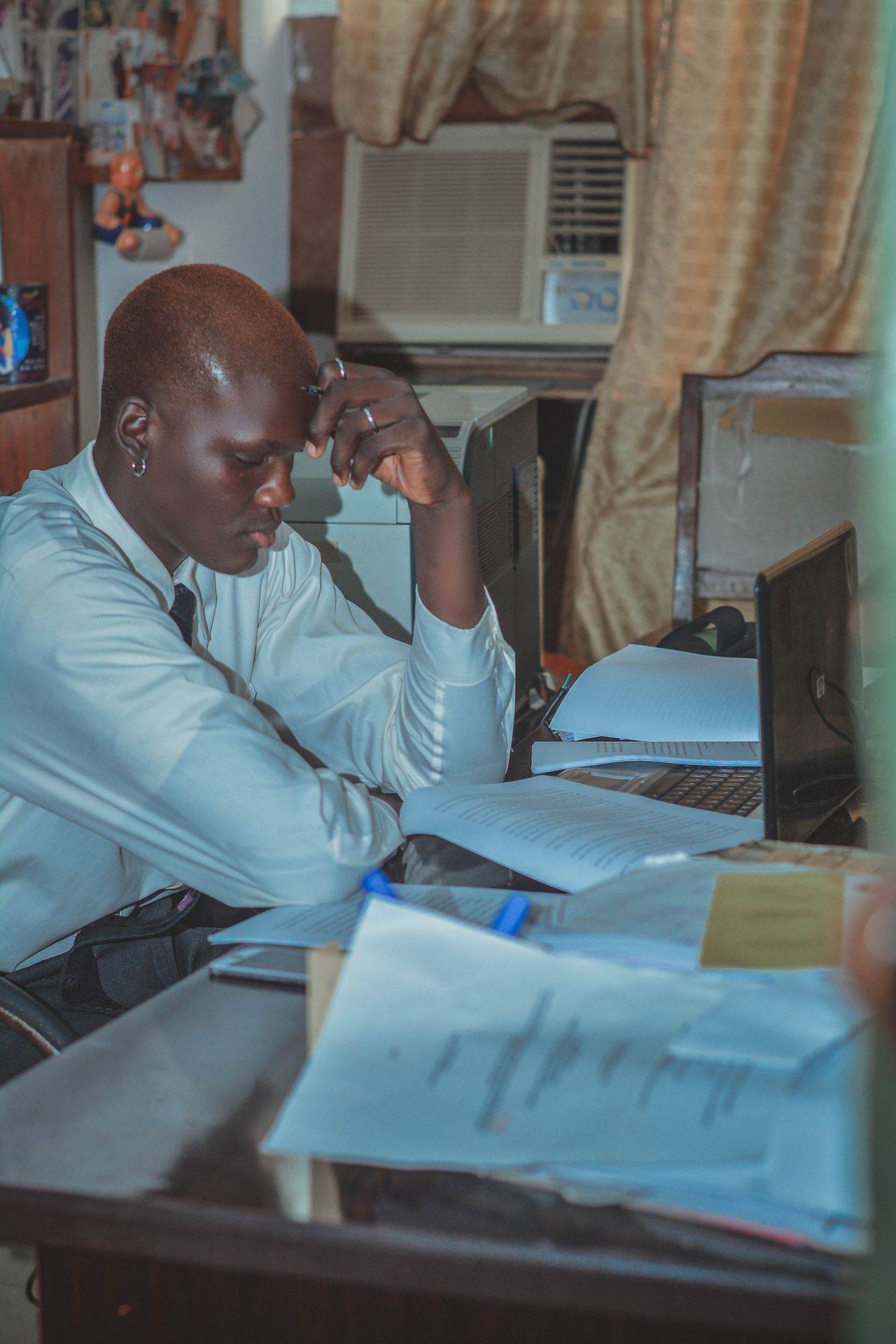 Professional reviewing research documents beside a laptop in a real office