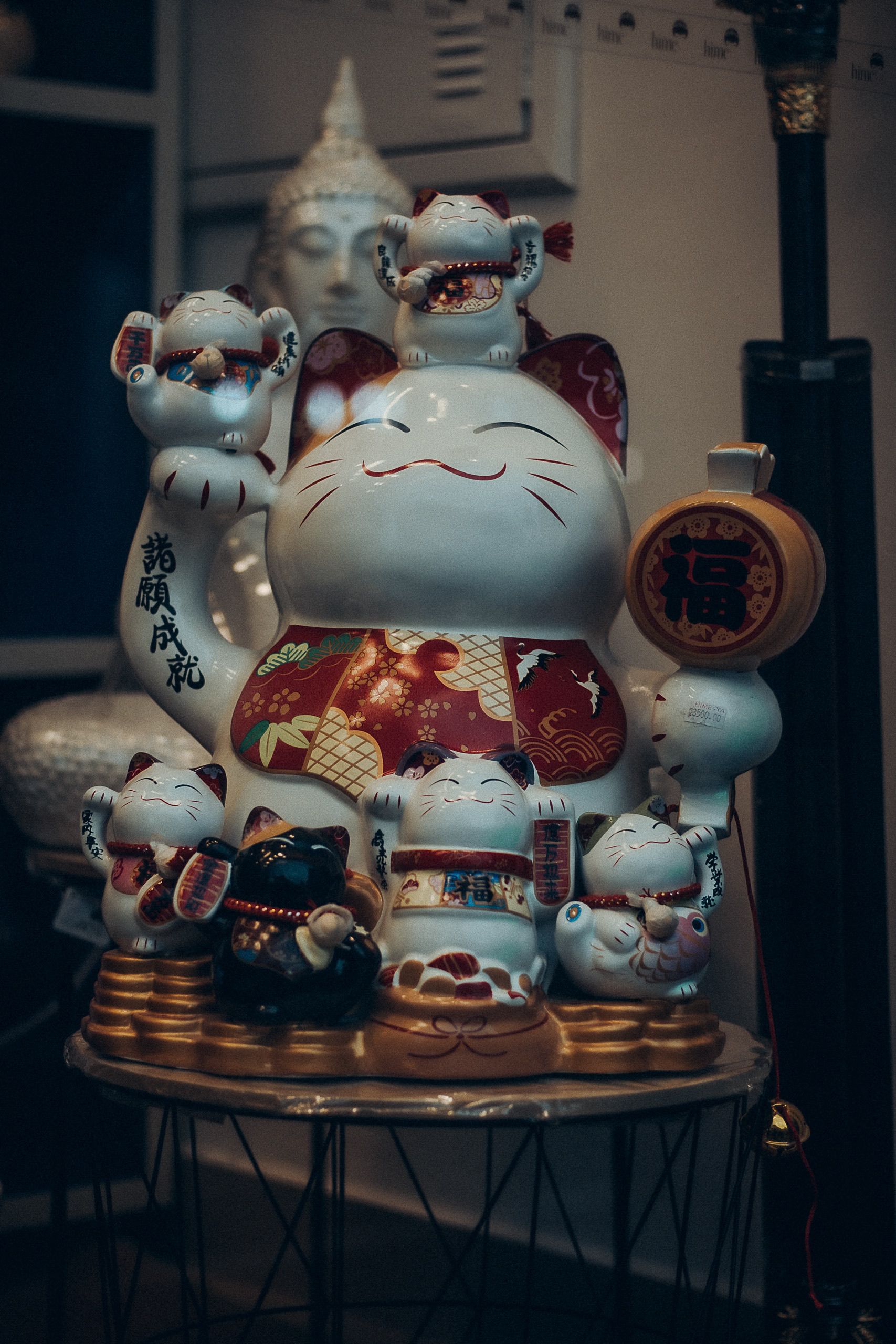 A grouping of traditional Japanese lucky cat figurines with intricate details and cultural significance.