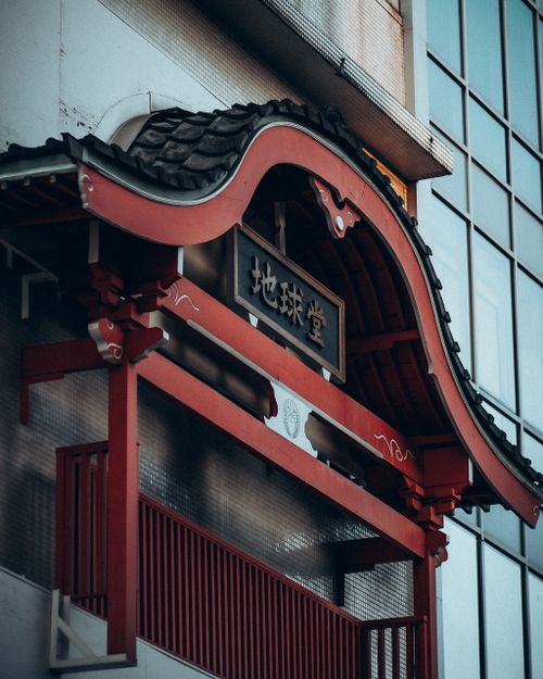 Free Japanese architectural detail with red wood and tiled roof in cityscape. Stock Photo