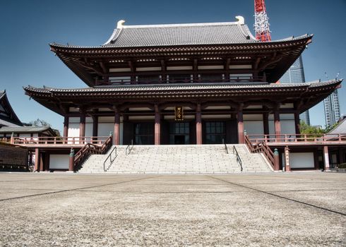 Serene view of Zojoji Temple in Tokyo, capturing traditional Japanese architecture under a clear sky.