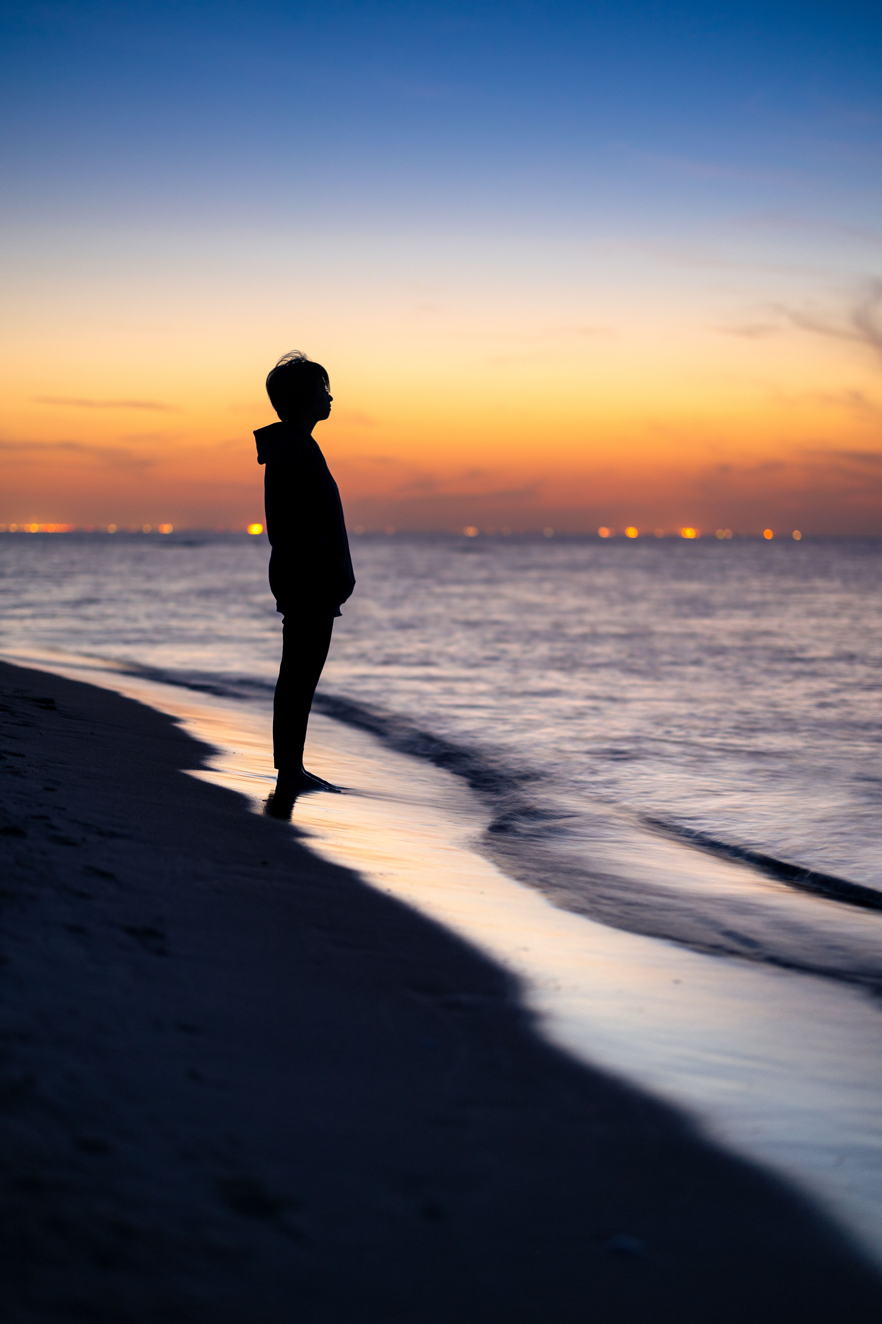 Silhouette of Woman Gazing at Sunset on Polish Beach · Free Stock Photo