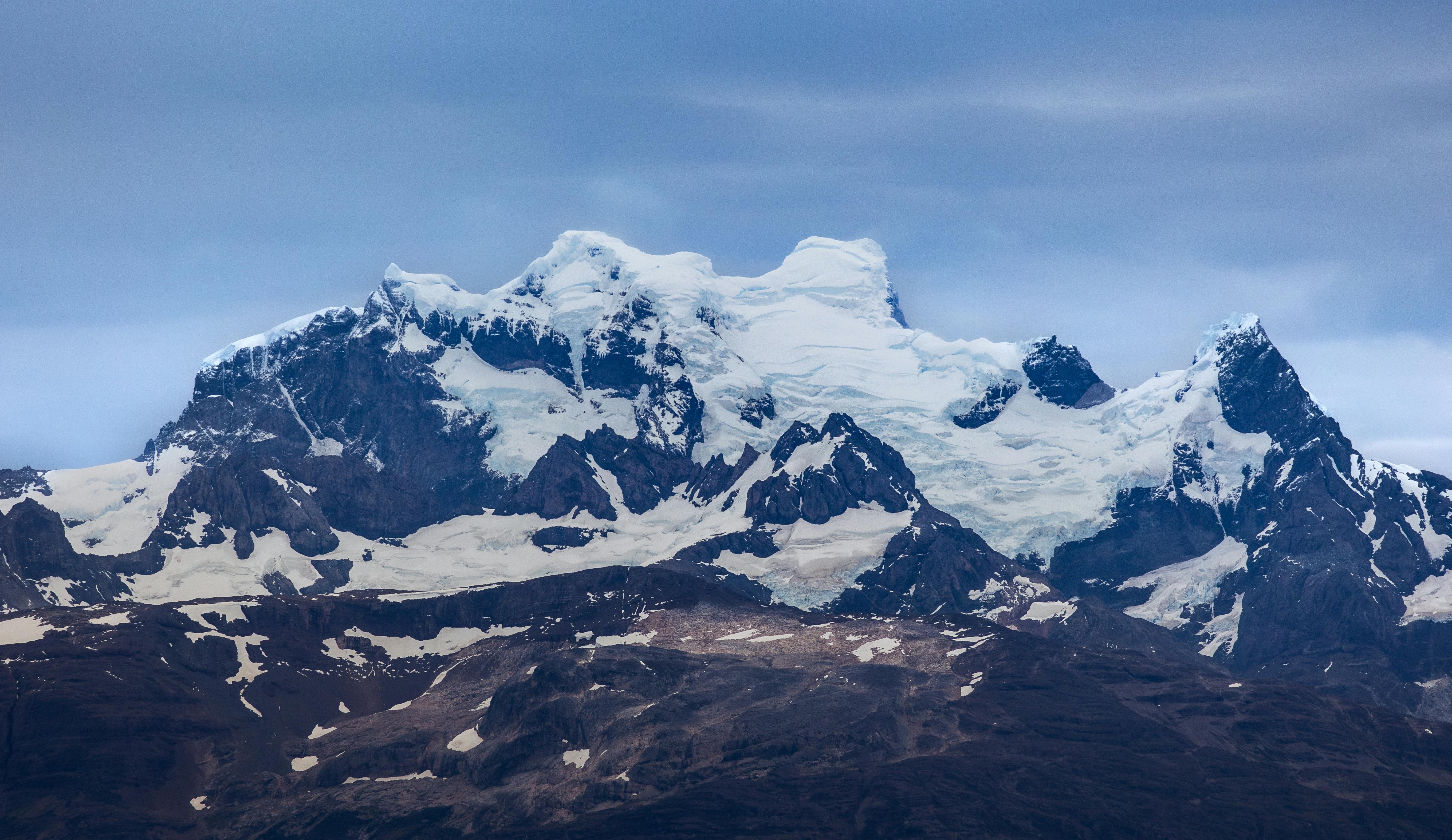 Stunning view of the Torres del Paine mountains in Patagonia, showcasing snow-covered summits under a cloudy sky. - Torres del Paine
