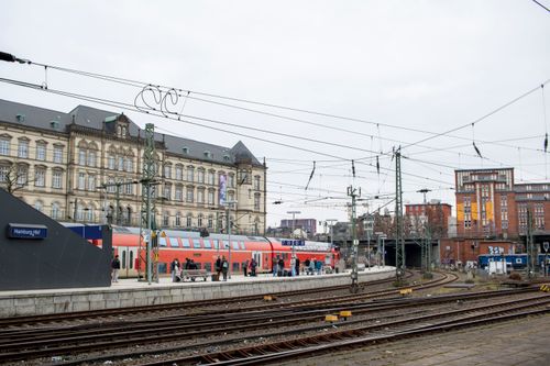 Free View of Hamburg Hauptbahnhof with trains and passengers on a cloudy day. Stock Photo