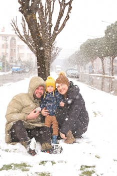 Family with child playing in the snow during winter, creating joyful memories outdoors.