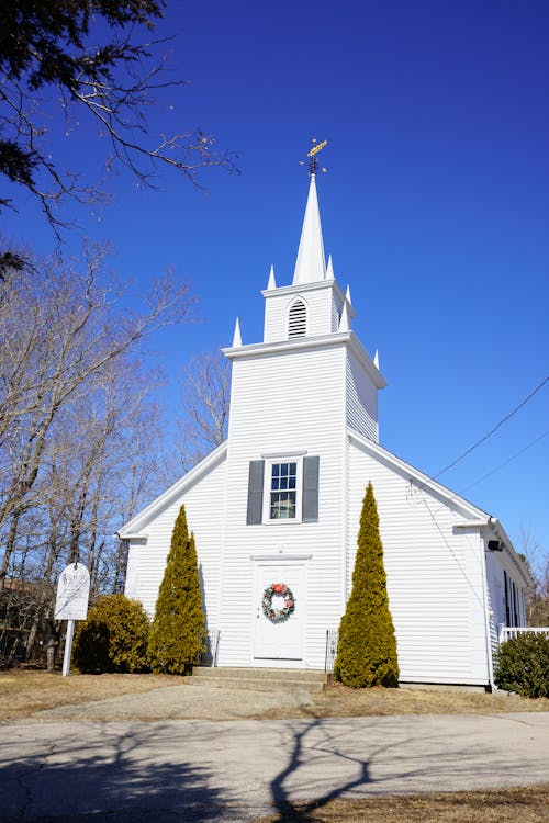 Gratis Una pintoresca iglesia blanca con un campanario bajo un cielo azul claro en Marshfield, Massachusetts. Foto de stock