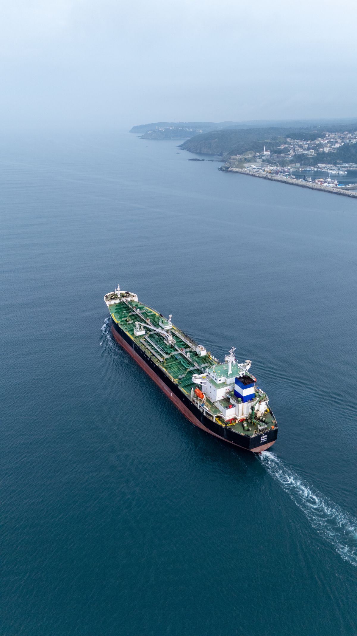 Aerial view of a cargo ship sailing near the coastline