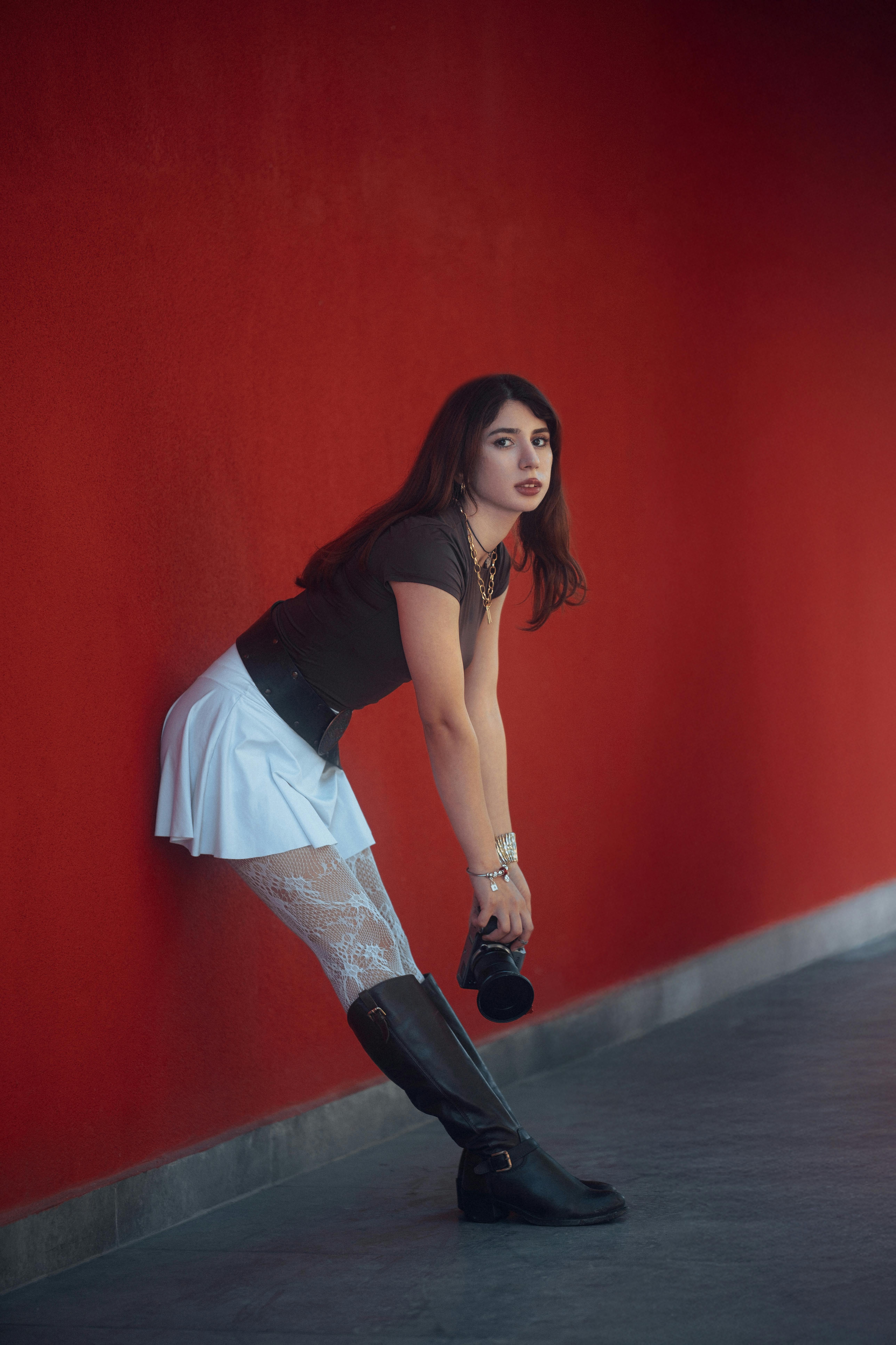 stylish woman posing against vibrant red wall