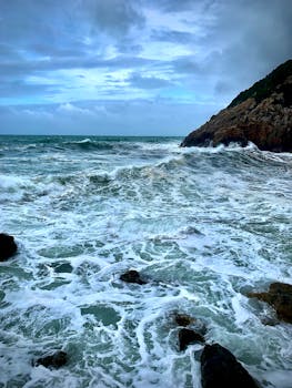 Dramatic sea waves crashing on rocks at Dénia coastline during golden hour
