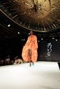 时装秀上，优雅的模特展示了橙色的设计师服装