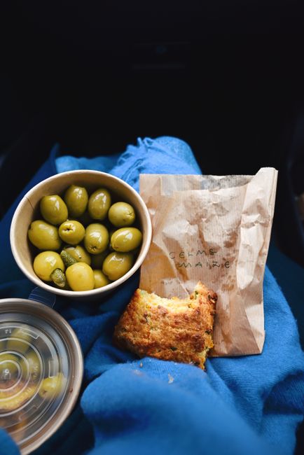A square of golden Mexican cornbread studded with corn kernels, melted cheese, and flecks of red and green jalapeño, cut open on a wooden board.