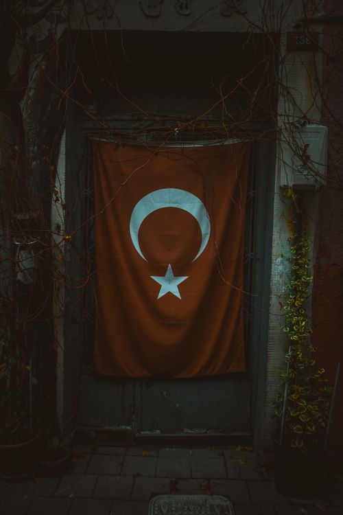 Free Moody capture of a Turkish flag displayed outside a doorway in an Istanbul street. Stock Photo