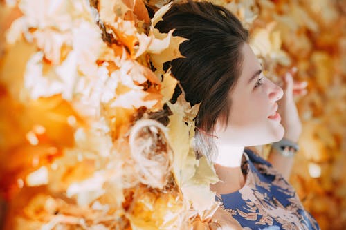 Selective Focus Photo of Woman Lying on Fallen Leaves