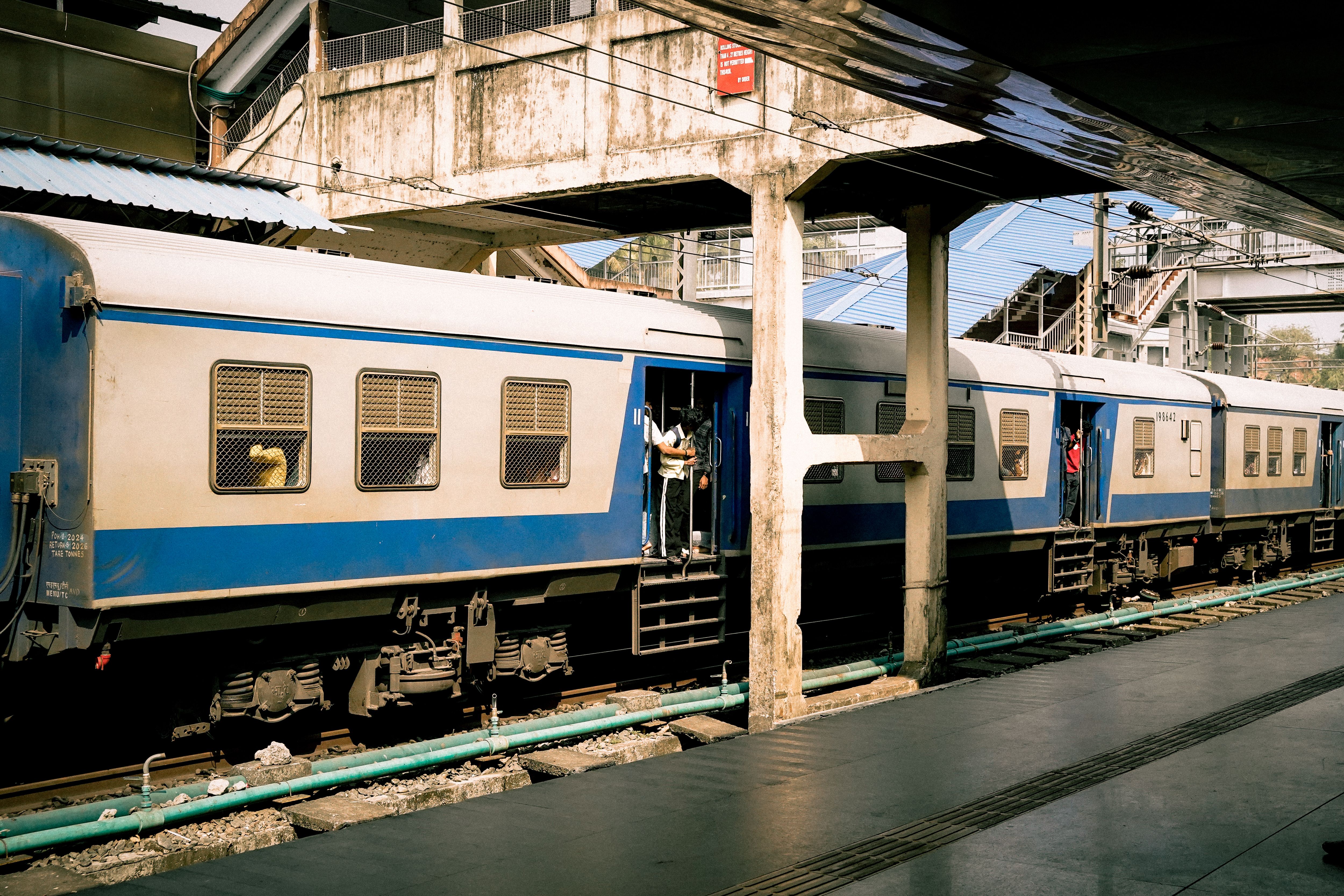 Passengers boarding a suburban train on a Mumbai platform