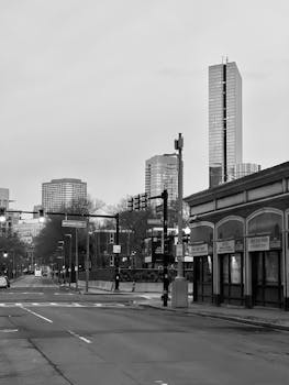Monochrome view of a city street with modern skyscrapers in the background.